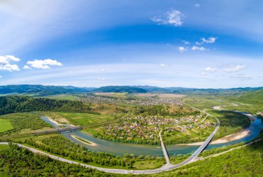 İlkbaharda vadideki dağların, nehrin ve köyün panoramik hava manzarası. Skyline, güzel doğa manzarası. Karpat Dağları. Ukrayna