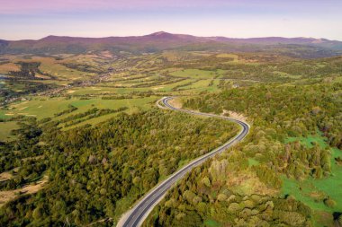 Baharda otobanı olan dağların ve vadinin havadan görünüşü. Güzel doğa manzarası. Karpat Dağları. Ukrayna