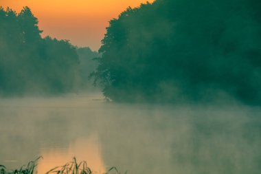 Gölün üzerinde büyülü bir gün doğumu. Sabahın erken saatlerinde sakin bir göl. Doğa manzarası