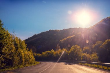 Dağ yolunda araba kullanmak. Güneşli bir günde boş bir yol. Dağ manzaralı arabanın görüntüsü