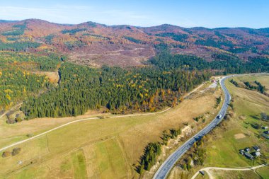 Sonbaharda dağ yolu ve köyün panoramik hava manzarası. Güzel bir kır manzarası. Karpat Dağları. Ukrayna
