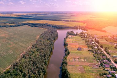 Kırsal alan, hava manzarası. Baharda ekili ve yeşil tarlalar, dere, köy ve orman manzarası