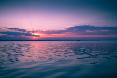 Gün batımında renkli bulutlu bir gökyüzü. Denizin üzerinde gün batımı. Rengi değişmiş. Gökyüzü dokusu. Soyut doğa arkaplanı