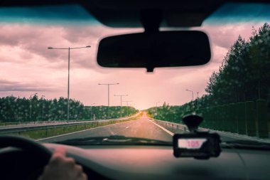 Yağmurlu bir havada gün batımında otobanda araba sürmek