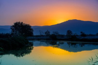 Akşamları dağ manzarası. Dağlara karşı güzel kıyı şeridi. Kuzey İsrail 'deki Hula Vadisi. Gün batımında.