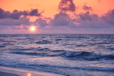 Sakin denizin üzerinde gün doğumu. Sabah erkenden. Yazın deniz manzarası