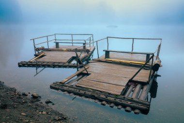 Sisli bir sonbahar sabahında gölde iki eski ahşap sal. Ukrayna 'daki Karpatlar' daki Synevyr Gölü. Zakarpattia bölgesindeki Synevyr Polyana Ulusal Parkı. Ukrayna, Avrupa