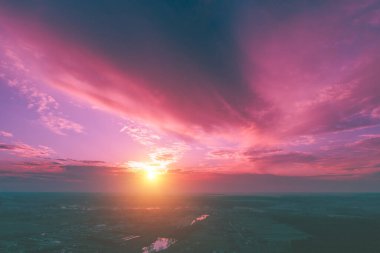 Sonbaharda kırsalda büyüleyici dramatik bir gün batımı. Akşamları kırsal alan. Derenin, köyün ve tarıma elverişli alanların havadan görüntüsü. Panoramik görünüm