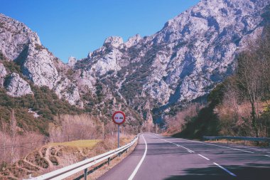 Güneşli bir günde güzel bir dağ manzarasının ön camdan görünüşü. Ulusal Park Picos de Europa 'da bir dağ yolunda araba kullanmak. Cantabria, İspanya, Avrupa