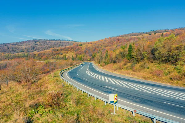 Sonbahar dağlarında dolambaçlı bir yol. İHA görüntüsü. Güzel doğal manzara. Karpatlar. Ukrayna