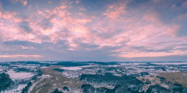 Panoramic top view of winter snowy countryside at sunset