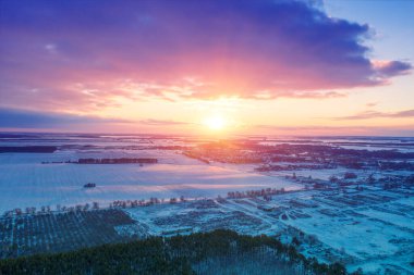 Gün batımında kışın karlı kırsal bölgelerinden manzara