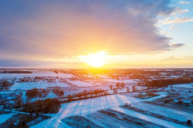 Gün batımında kışın karla kaplı kırsal hava manzarası