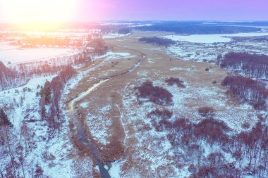 Kış günbatımında çayırdaki rüzgarlı dere manzarası.