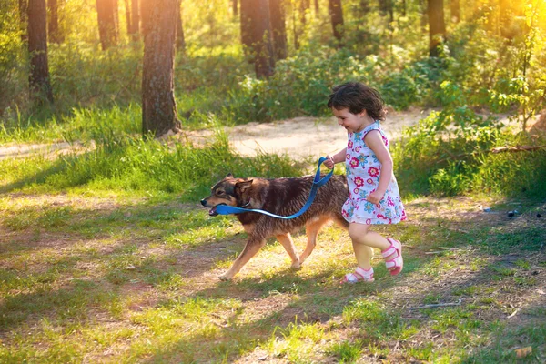Felice bambina in esecuzione con il cane — Foto Stock