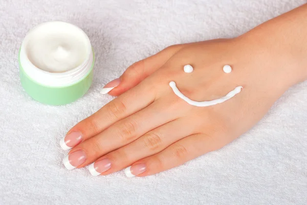 Crème sourire visage sur les mains féminines — Photo