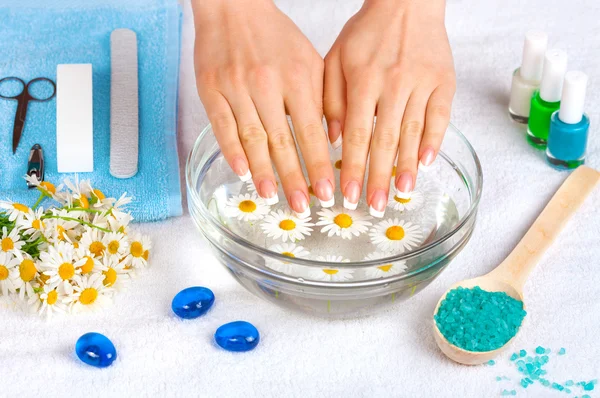 Hermosas manos de mujer con perfecta manicura francesa en tazón de agua —  Fotos de Stock