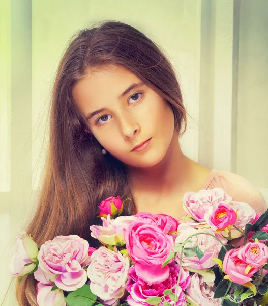 Chica joven con pelo castaño largo y flores —  Fotos de Stock