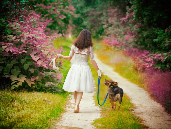 Mulher andando descalça com cão — Fotografia de Stock