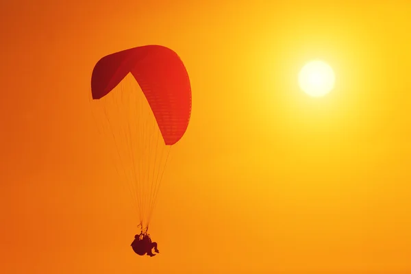 Paraglider huimasti auringonlaskun aikaan — kuvapankkivalokuva