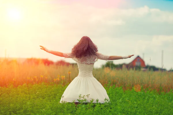 Flicka i vit klänning dans på fältet — Stockfoto