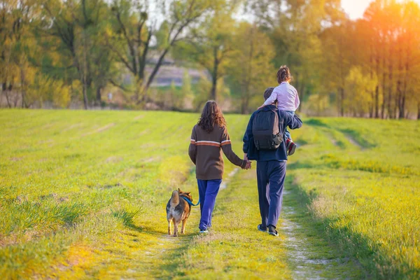 Glückliche Familie geht mit Hund spazieren — Stockfoto