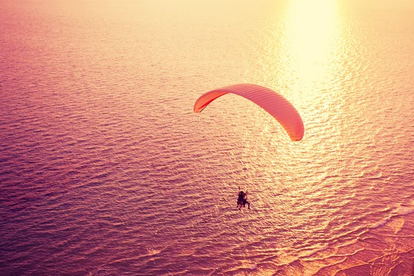 Paraglider kohoamassa yli meren — kuvapankkivalokuva