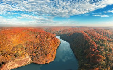 Bir dağ nehrinin tepesinden panoramik manzara ve sonbaharda güzel kızıl dağlar.