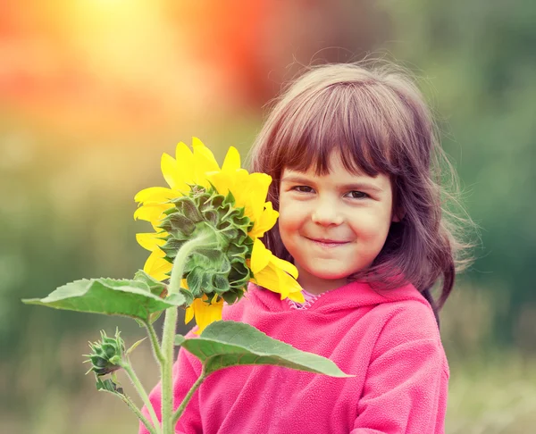 Little girl with sunflower — Stock Photo, Image