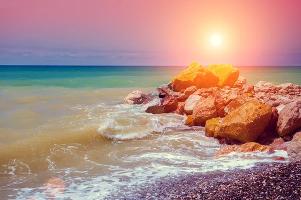 岩が多い海岸に沈む夕日 — ストック写真