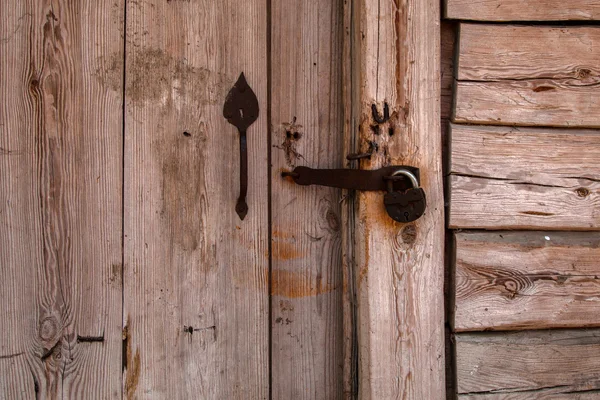 Puerta de madera vieja cerrada con un gran perno — Foto de stock
