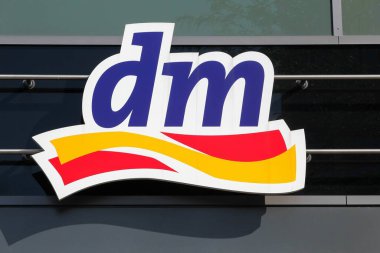 Berlin, Almanya - 12 Temmuz 2020: Duvardaki DM logosu. Dm-drogerie markt, kozmetik, sağlık ürünleri, ev ürünleri ve sağlıklı gıda satan bir perakende mağaza zinciri.