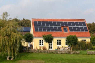 Çatıda güneş panelleri olan ev.