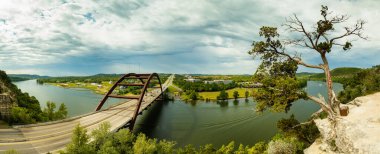 Panoramic view of the beautiful through arch Pennybacker Bridge in Austin, Texas on a cloudy stormy day. clipart