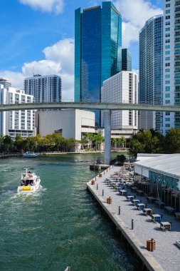 Miami, Florida ABD - 30 Ocak 2021: Brickell bölgesinde nehir boyunca yüzen yüksek gökdelenleri ve tekneleri olan şehir merkezi..