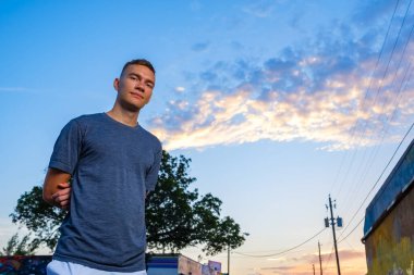 Gün batımında şehir merkezinde yakışıklı bir genç adam.