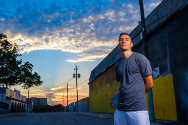 Gün batımında şehir merkezinde yakışıklı bir genç adam.