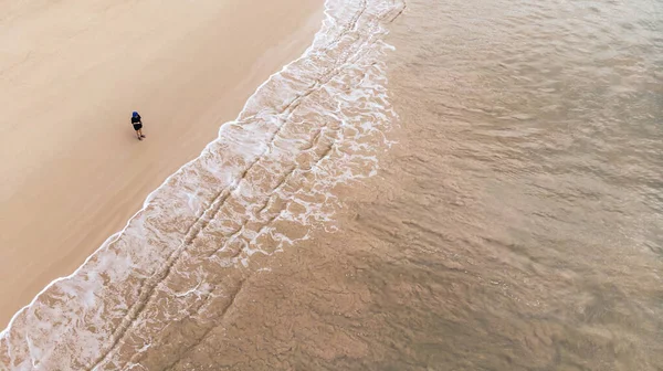 Güzel bir kumsalın en güzel manzarası ayakta duran bir kadınla.