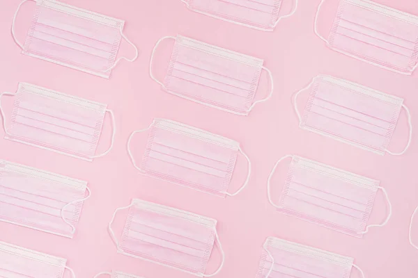 Pink masks on pink paper background. Creative concept. Pattern. Flat lay.