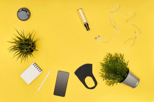 Máscara plana, taza, antiséptico, teléfono, suculento, bloc de notas, auriculares en amarillo — Foto de Stock