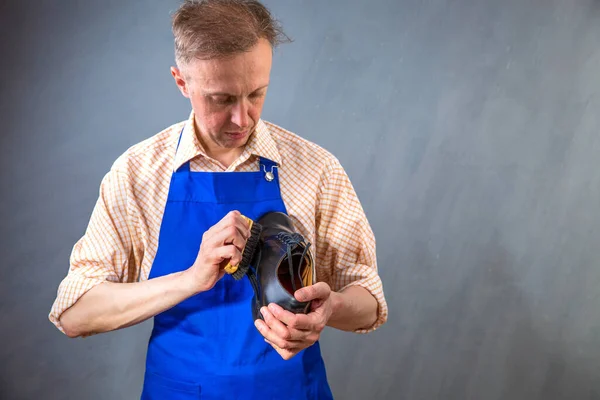 The master is cleaning shoes. Shoemaker