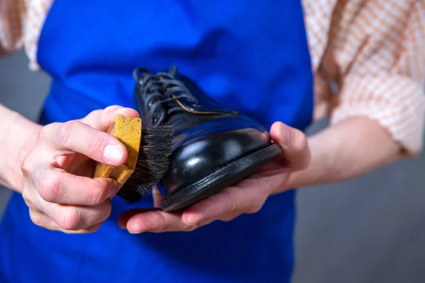 The master is cleaning shoes. Shoemaker