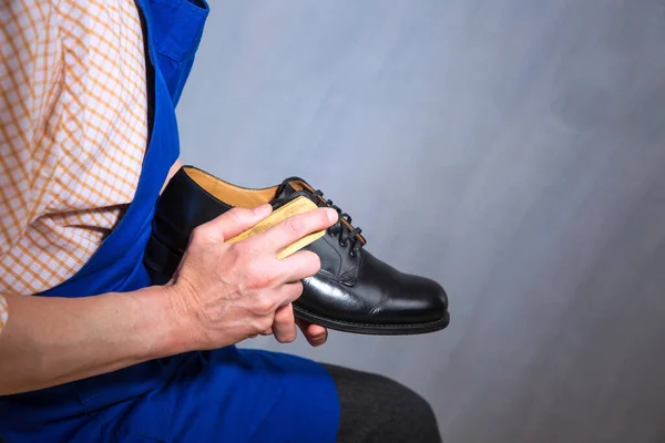 The master is cleaning shoes. Shoemaker