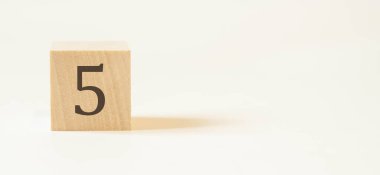 Beyaz arka planı olan tahta küpte beş numara. Mükemmel hedef..