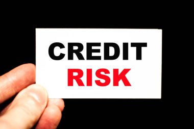İş adamının elinde CREDIT RISK 'in kısaltma metninin olduğu bir kart var. Yumuşak arkaplanlı iş konsepti fotoğrafçılığı.