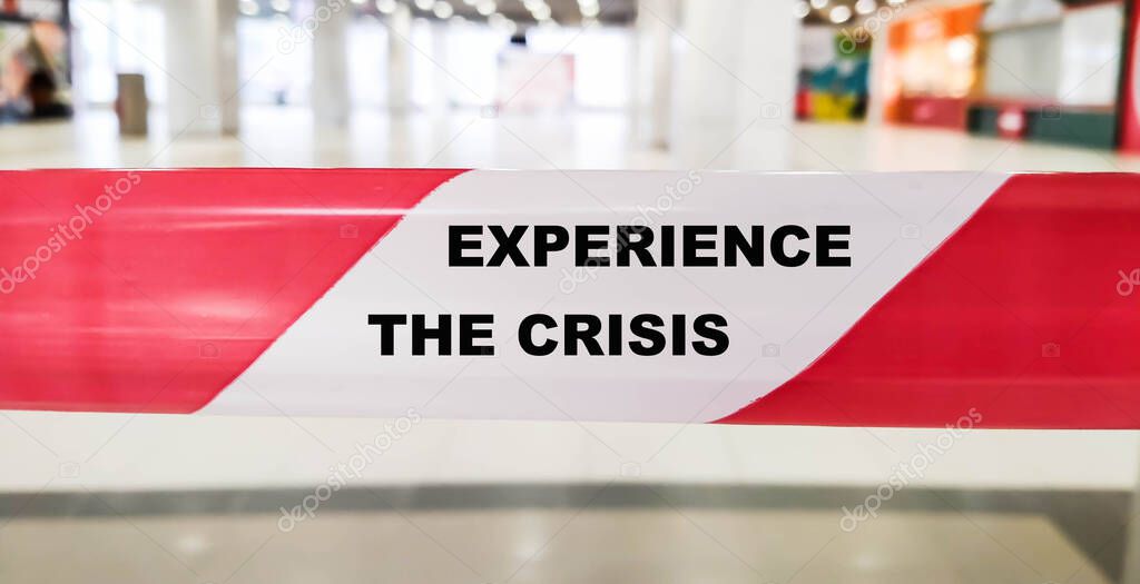 The expression EXPERIENCE THE CRISIS on the separating red tape.
