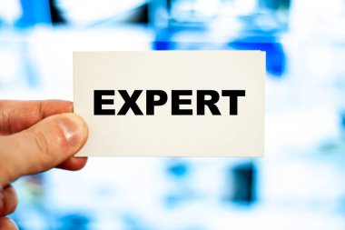 A businessman is holding a business card with the word - Expert.