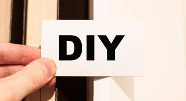 Kitap arkaplanlı beyaz kartvizit üzerine DIY metin.
