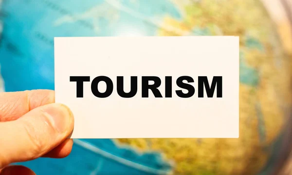 Viajante Detém Papel Com Palavra Turismo Fundo Mapa — Fotografia de Stock
