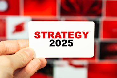 Strateji 2025 kelimesi bir iş adamının elindeki kartvizitte yazıyor.